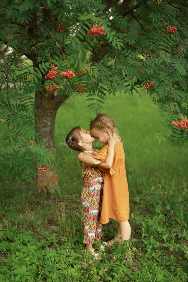 Girl Sweetly And Tenderly Kisses Her Older Sister On The Forehead 