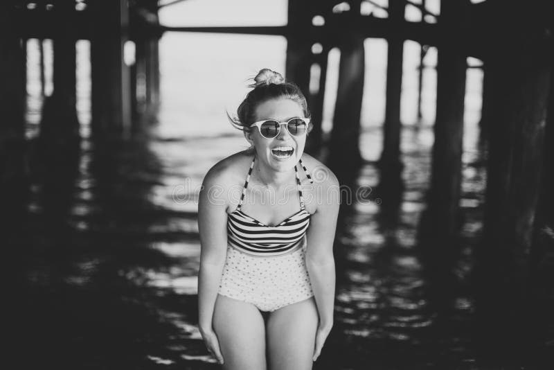 Girl in fashion bathing suit under pier in Southern California. Girl in fashion bathing suit under pier in Southern California