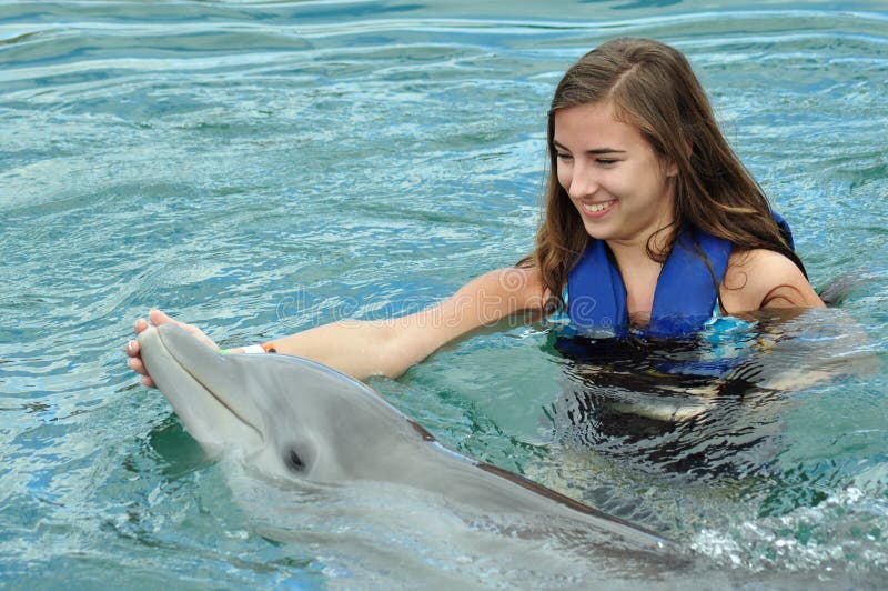 Young girl swimming with Dolphin in pool