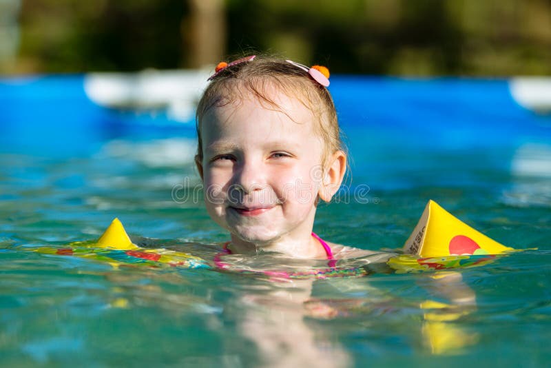 Girl Swims in the Pool in the Pillows. Stock Photo - Image of hands ...