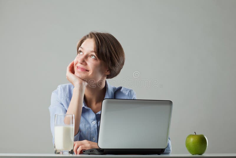 Girl at the table with a laptop stock photo