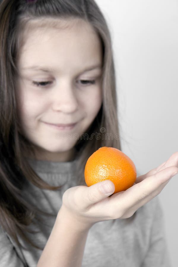The girl and a tangerine stock image. Image of harmony 11749223