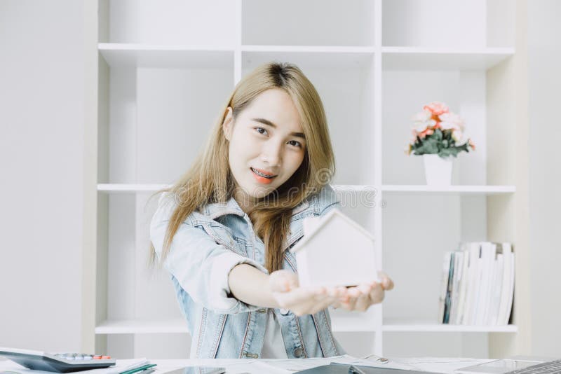 Girl teen happy smile with home model in her hand for buy or sale house for future living concept royalty free stock image Girl teen happy smile with home model in her hand for buy or sale house for future living concept royalty free stock image
