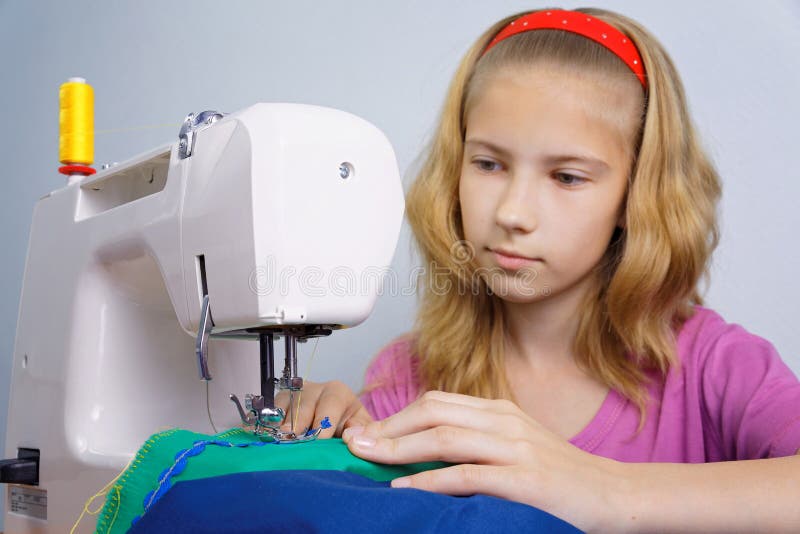 Girl learns to sew on an electric sewing machine royalty free stock photo Girl learns to sew on an electric sewing machine royalty free stock photo