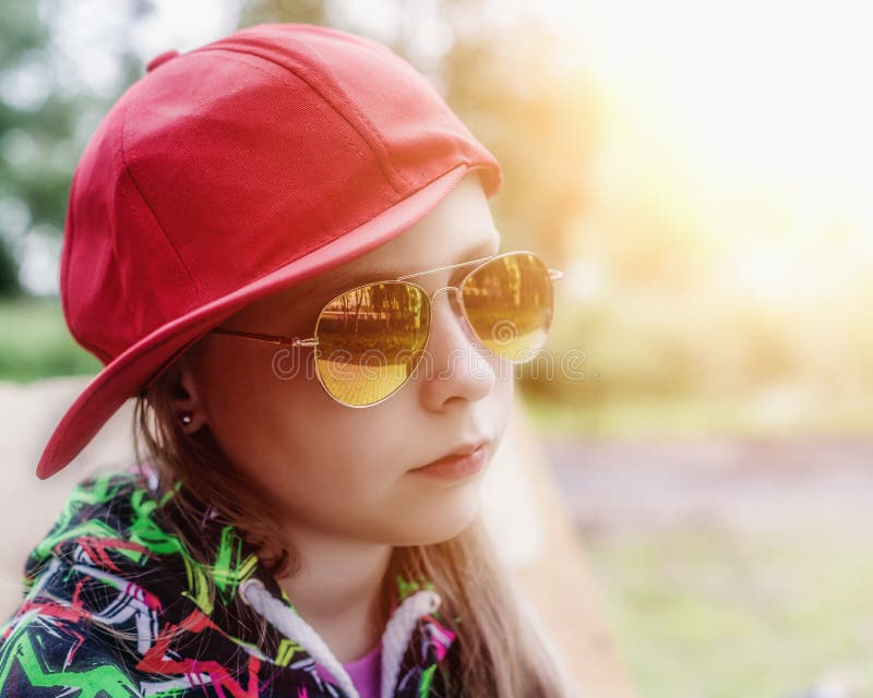 Beautiful girl in sunglasses and a cap outdoors. Beautiful girl in sunglasses and a cap outdoors.