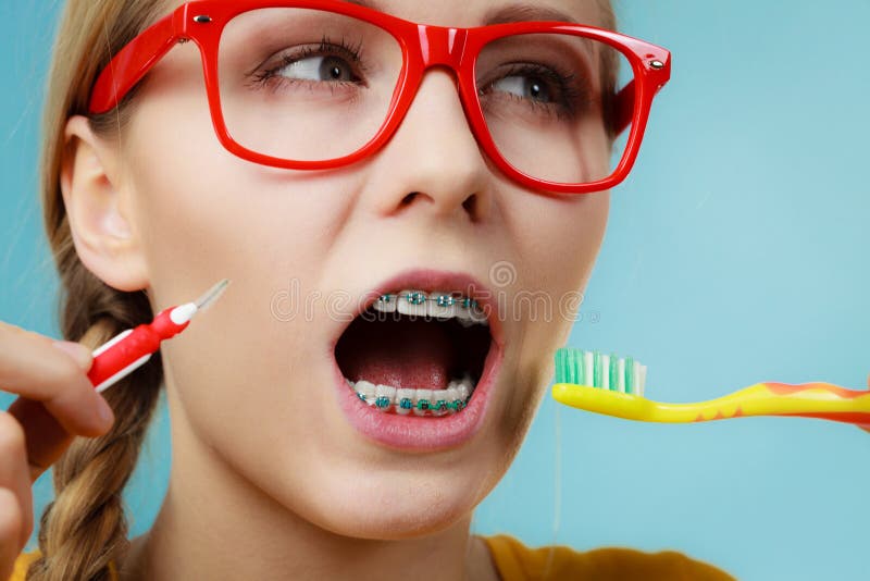 Girl with teeth braces using interdental and traditional brush