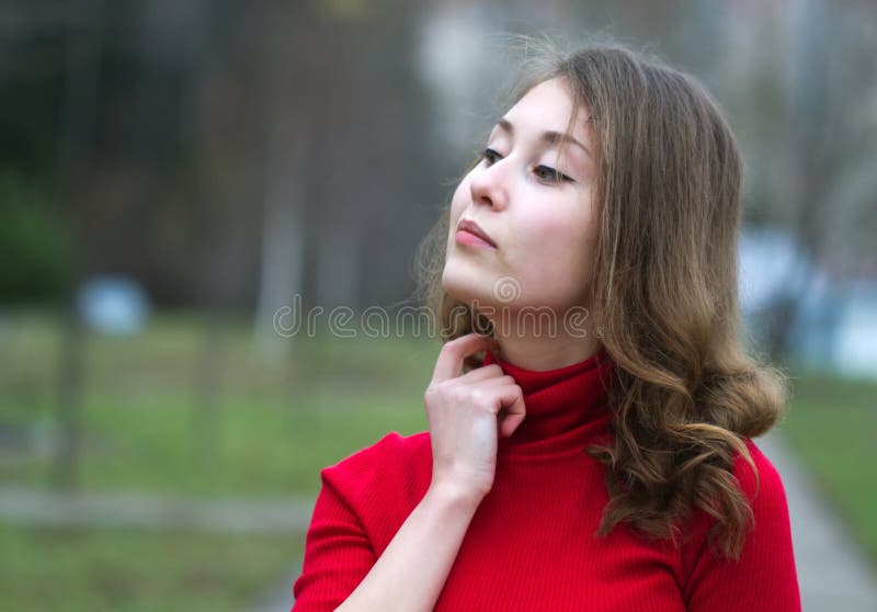 Portrait of an attractive beautiful pretty cute young caucasian successful cheerful thinking and looking up woman (girl, female, person, model) in red sweater against blurred background. Portrait of an attractive beautiful pretty cute young caucasian successful cheerful thinking and looking up woman (girl, female, person, model) in red sweater against blurred background.