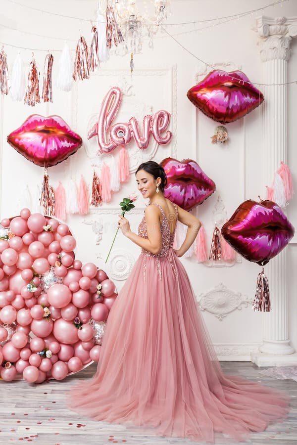 Happy woman having fun on saint valentine`s day. woman with heart baloons and presents. love