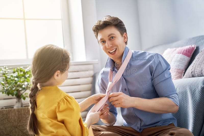 Girl tying tie for daddy stock photo Girl tying tie for daddy stock photo