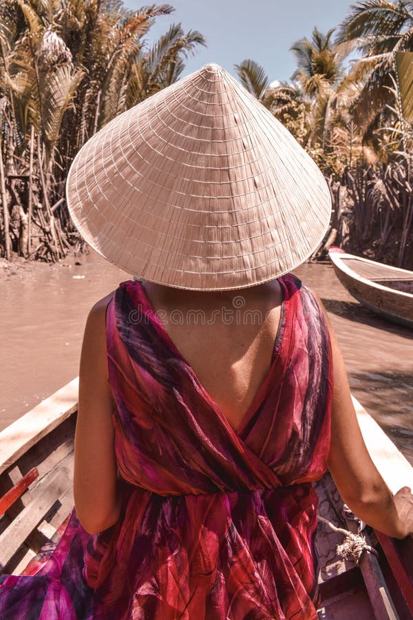 Girl in typical cylindrical Vietnamese hat floating on a boat through mangroves at Mekong Delta stock images Girl in typical cylindrical Vietnamese hat floating on a boat through mangroves at Mekong Delta stock images