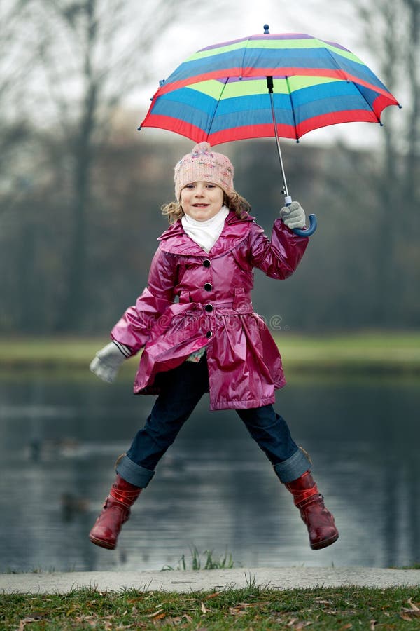 Young Girl Outdoors in Rain with Umbrella Smiling Stock Photo Image