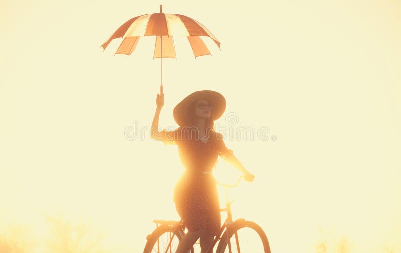 Girl with umbrella on a bike