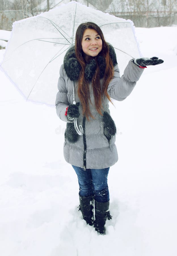 Girl with umbrella catches the snow