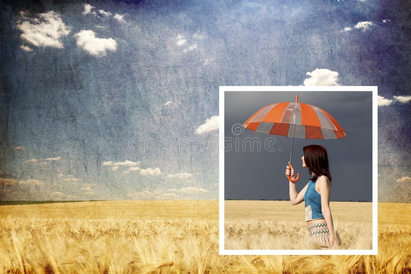 Girl with umbrella in storm at wheat field