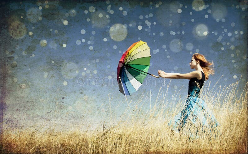 Girl with umbrella at windy grass