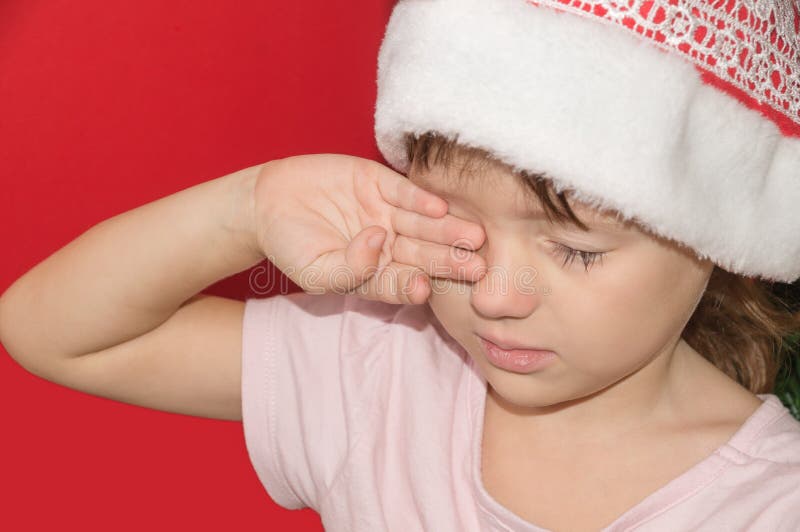 Girl in Santa hat upset and crying. Girl in Santa hat upset and crying