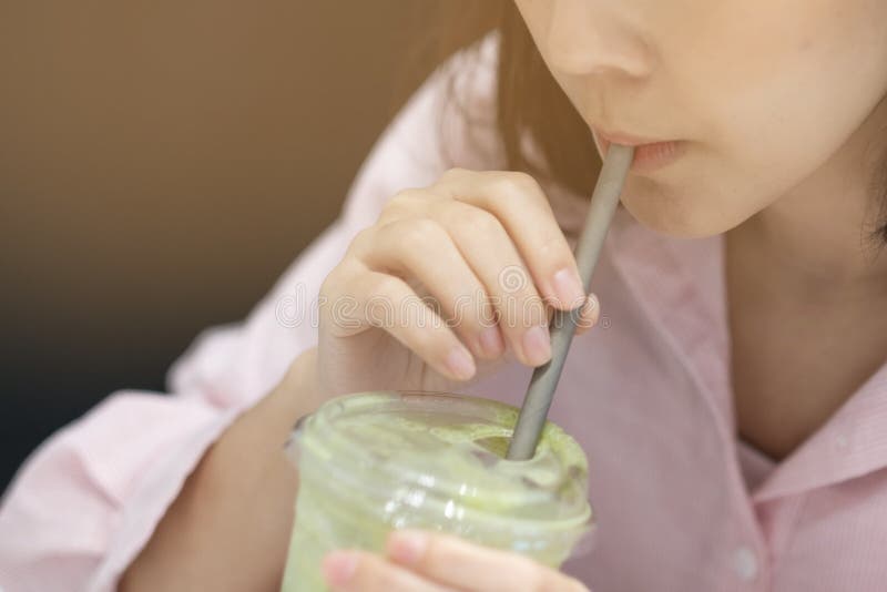 The girl used a Paper straw for drinking some water in coffee shop royalty free stock images The girl used a Paper straw for drinking some water in coffee shop royalty free stock images