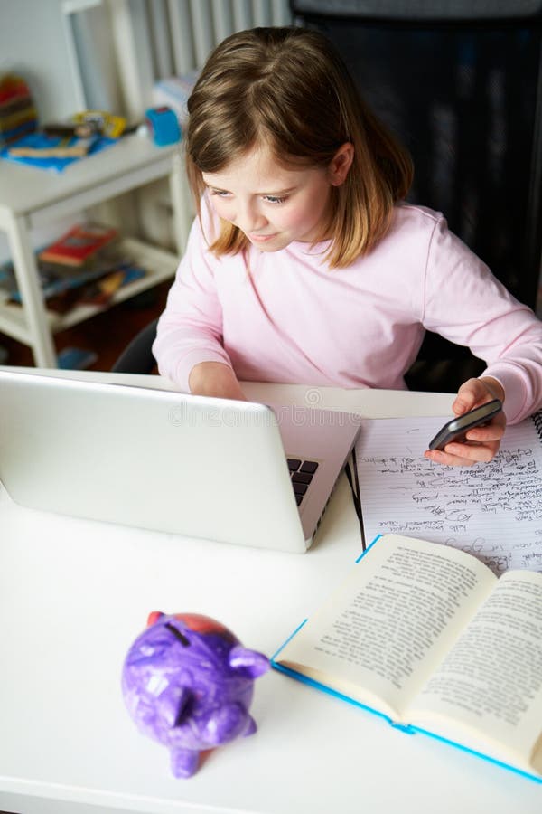 Girl Using Mobile Phone Instead Of Studying In Bedroom