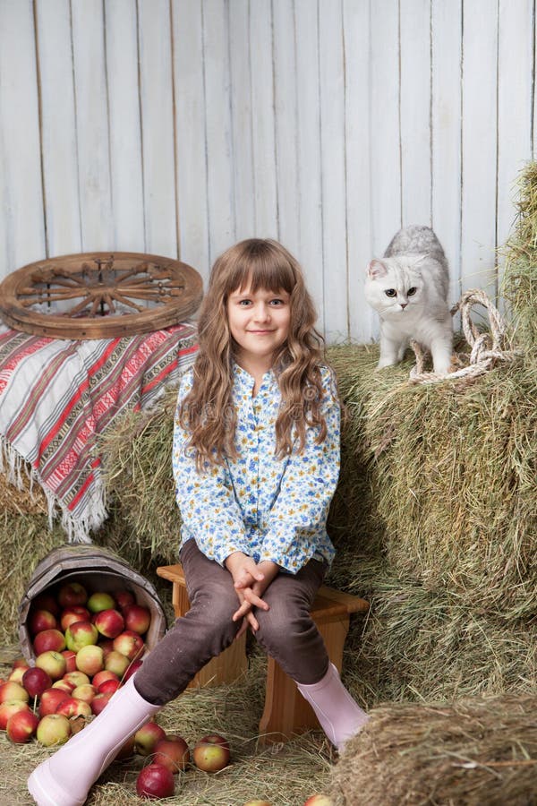 Girl villager and cat on hay stack in barn