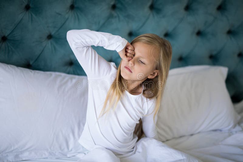 Girl waking up on bed in bedroom