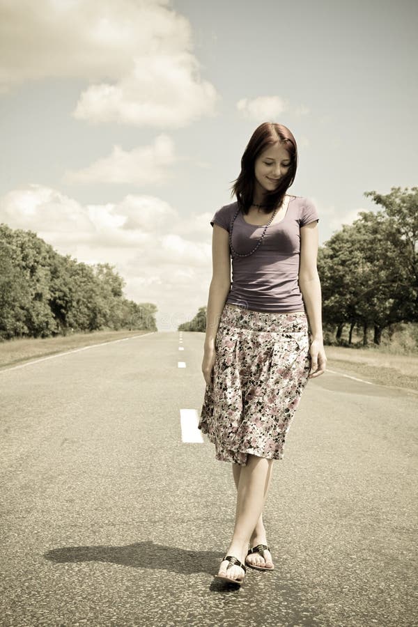 Girl walking by foot on road in vintage style