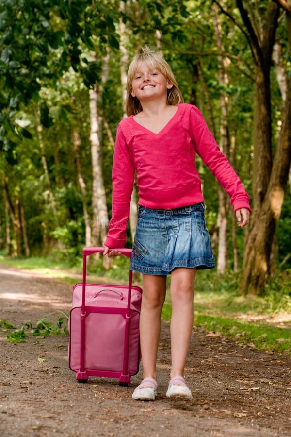 Girl walking with her pink suitcase