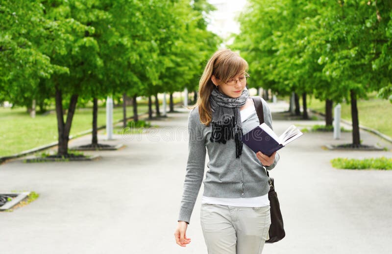 The girl walks, reading the book