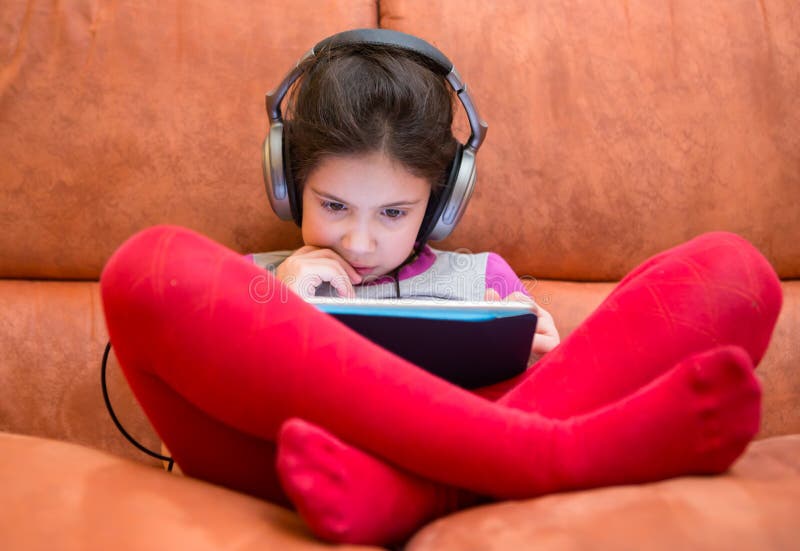 Young girl watching tablet pc with headphones