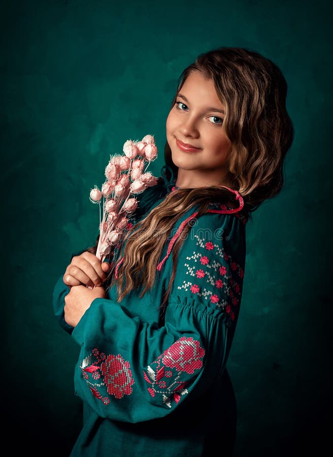 Dievča má na sebe vyšívanú košeľu, národné ukrajinské slovanské oblečenie, tmavozelenú košeľu.