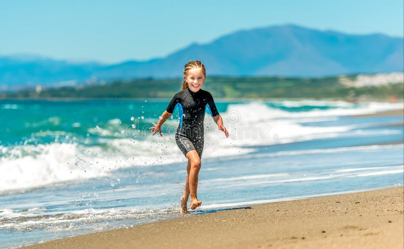 Girl In A Wetsuit Running Along The Beach Stock Image Image Of