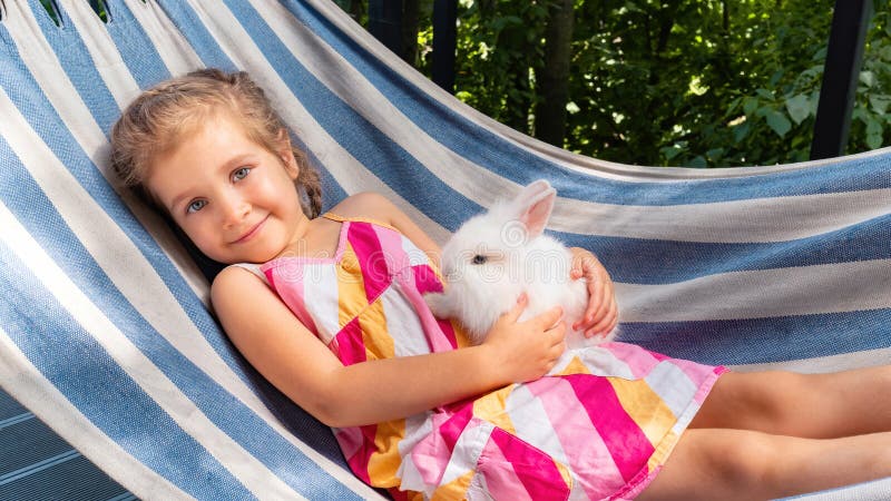 Blanco conejito descansa sobre el hamaca en verano sobre el soleado.