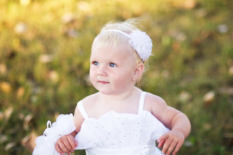 Girl in a white wedding dress on the grass