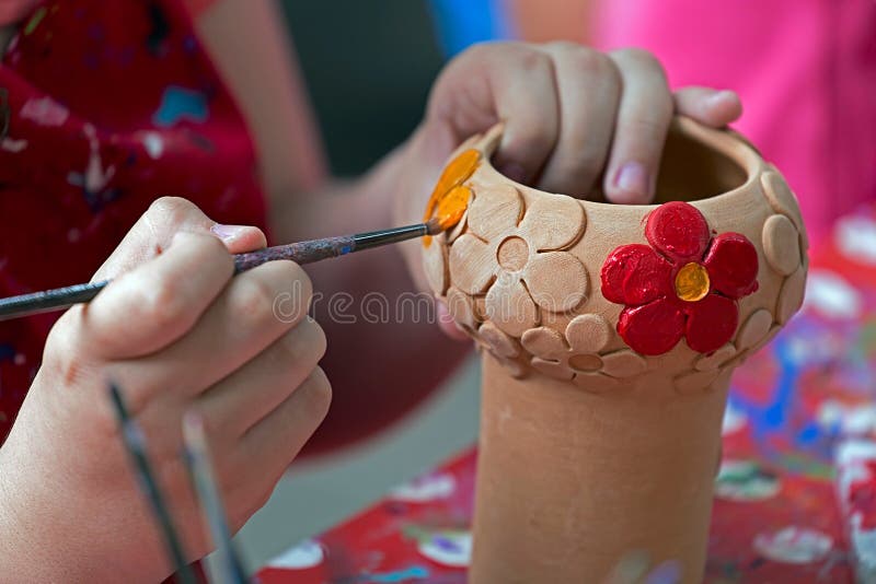 TIMISOARA, ROMANIA - JUNE 1, 2016: Girl who paints a ceramic bowl. Workshop organized by the City Hall Timisoara with the occasion of the International children Day.