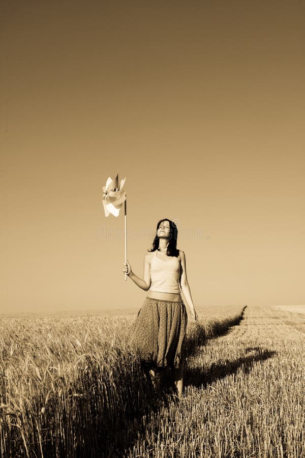 Girl with wind turbine at wheat field