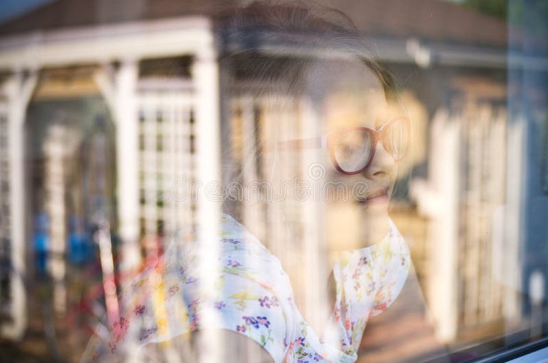 Girl in a window with garden refelctions
