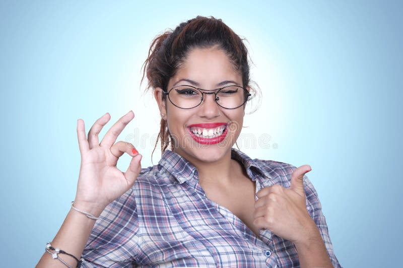 Free Photo  Young sporty woman winking and smiling showing two fingers  standing over purple wall