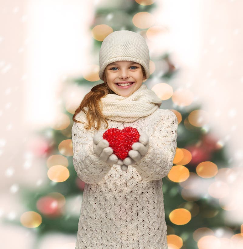 Girl in winter clothes with small red heart