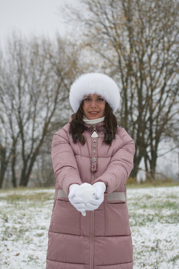 Woman in winter clothes on a walk in the park. There is a lot of