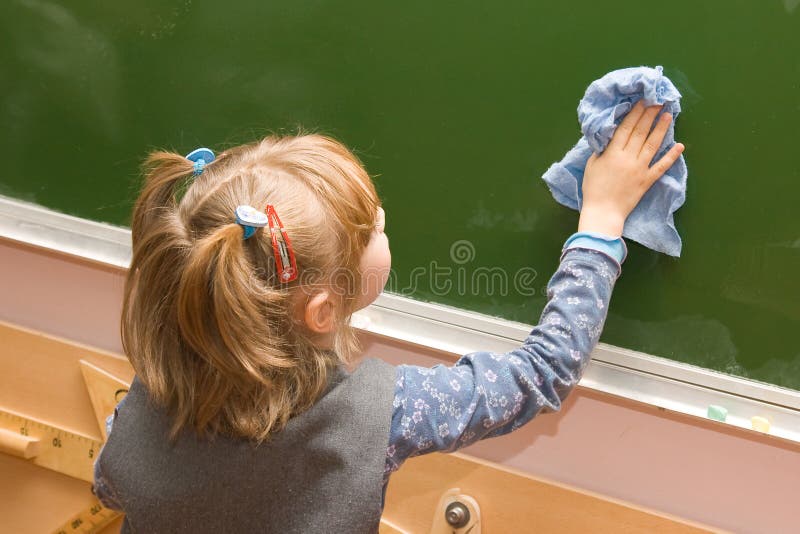 The girl wipes a blackboard