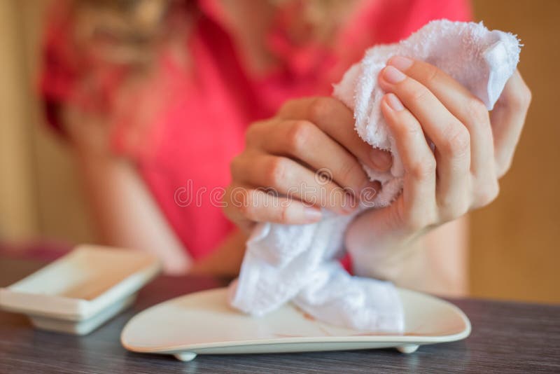 The girl wipes her hands with a hot towel rolled into a roll in stock image The girl wipes her hands with a hot towel rolled into a roll in stock image