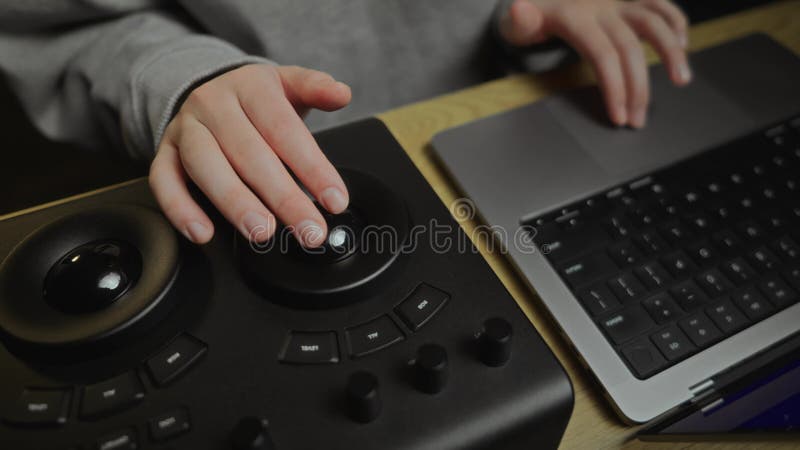 A girl working at a laptop and a color correction panel. Keyboard. A girl typing on the keyboard. Hands. Work on a