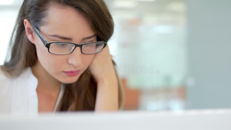 The girl in the workplace in the office, looking at the monitor screen.