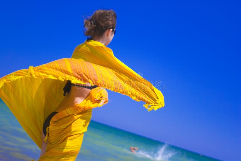 Bella e giovane donna di avvolgimento e lo agita, un giallo vaporoso sciarpa.