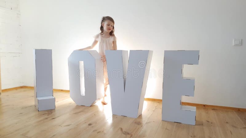 Girl 7 Years Old Playing with Big Cardboard 3D Standing Letters