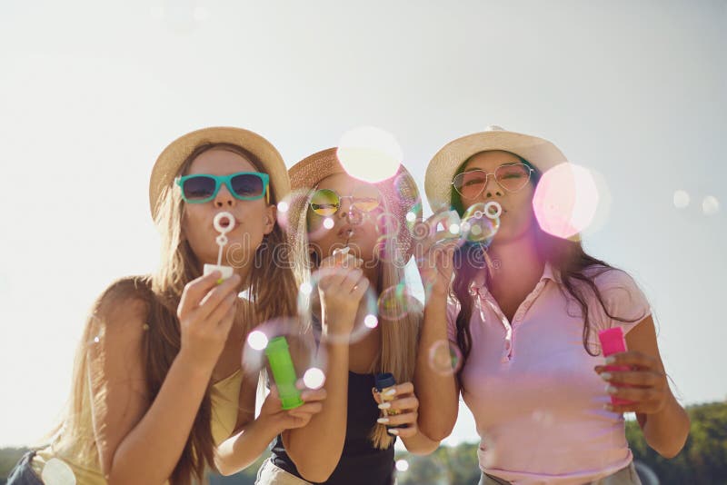 Girlfriends Blowing Soap Bubbles on the Beach. Stock Photo - Image of ...