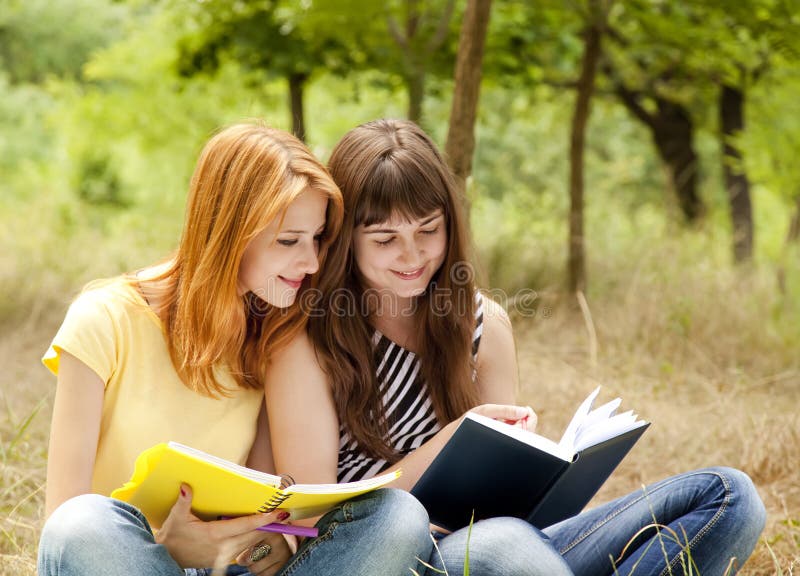 Girlfriends doing homework at the park.