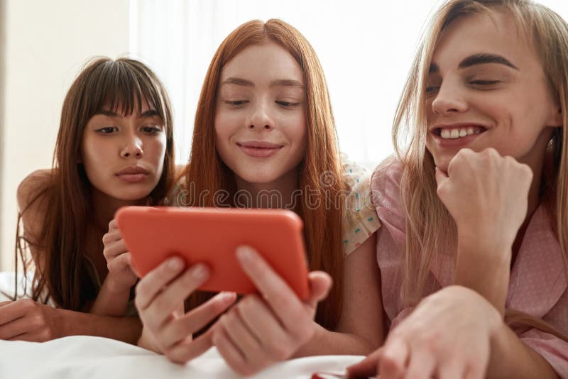 Girlfriends Watching Smartphone in Hand of Girl Stock Im photo