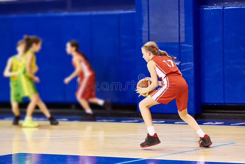 Girls athlete in sport uniform playing basketball. Childhood, blond.