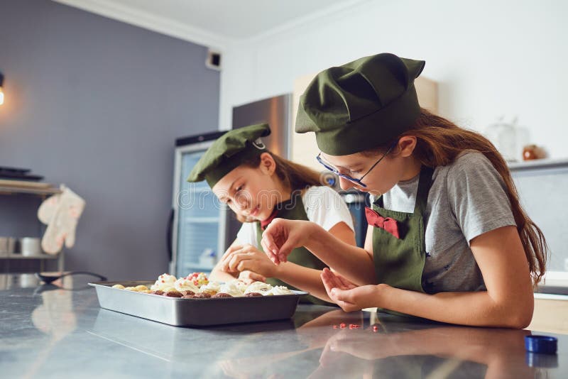 Girls children in cook uniforms in the kitchen. royalty free stock images Girls children in cook uniforms in the kitchen. royalty free stock images
