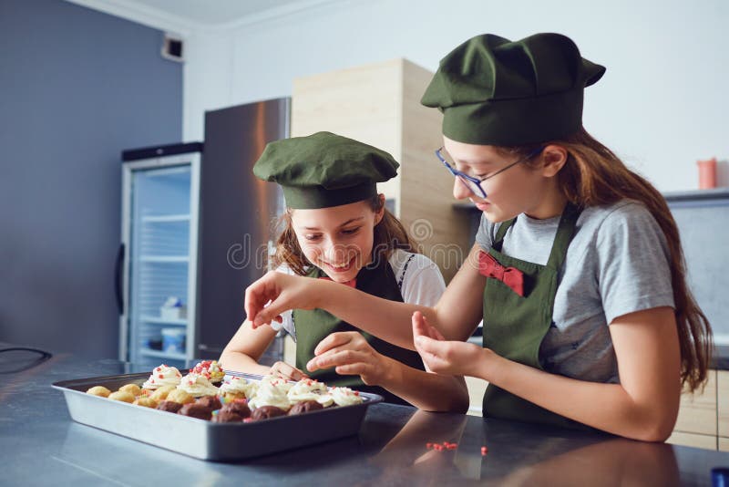 Girls children in cook uniforms in the kitchen. royalty free stock images Girls children in cook uniforms in the kitchen. royalty free stock images